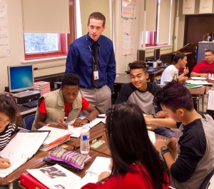 Teacher in a classroom with student sitting at a table